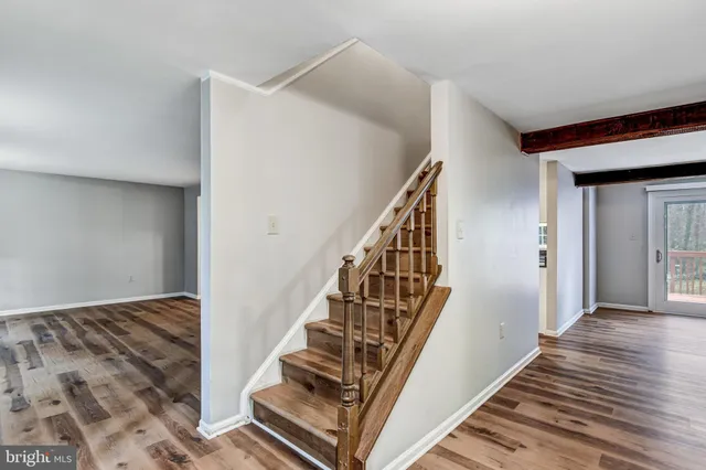 a view of a hallway with wooden floor and staircase