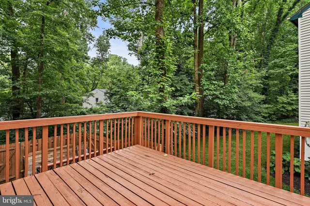 a balcony with wooden floor and trees in the back