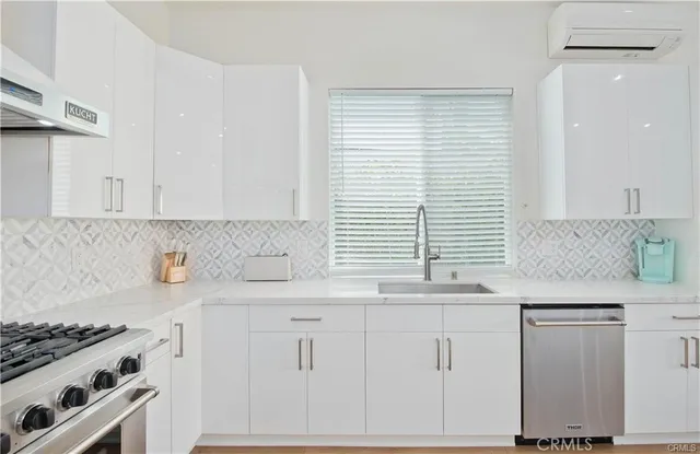 a kitchen with granite countertop white cabinets and a stove
