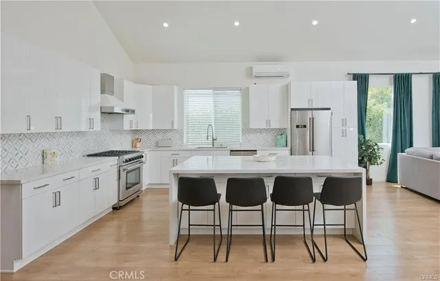 a large kitchen with kitchen island granite countertop a table and chairs in it