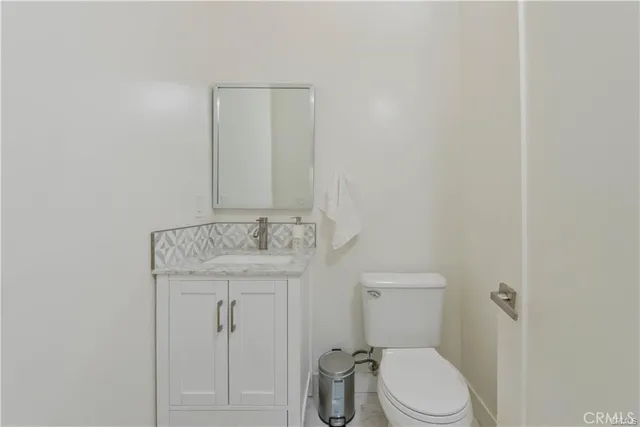 a bathroom with a granite countertop toilet and a sink