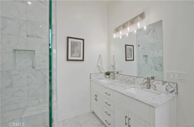 a bathroom with a granite countertop sink a mirror and a shower
