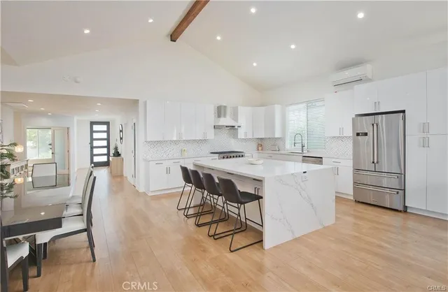 a kitchen with stainless steel appliances white cabinets and wooden floor