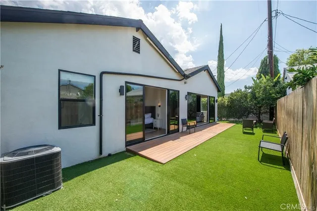 a view of a backyard with couches plants and large tree