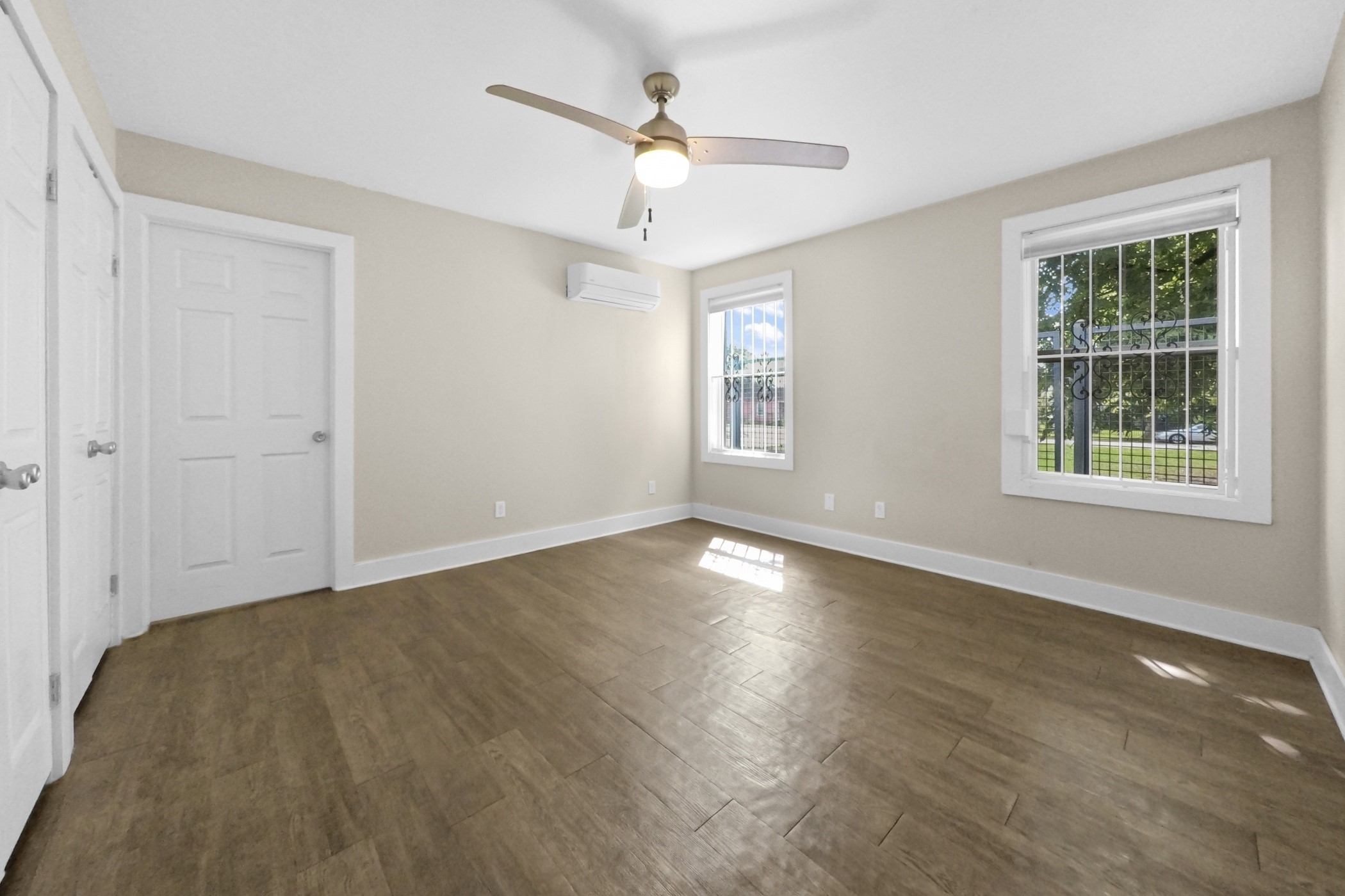1709 Dan Street Houston, TX 77020 - Photo 20 of 29 an empty room with wooden floor chandelier fan and windows