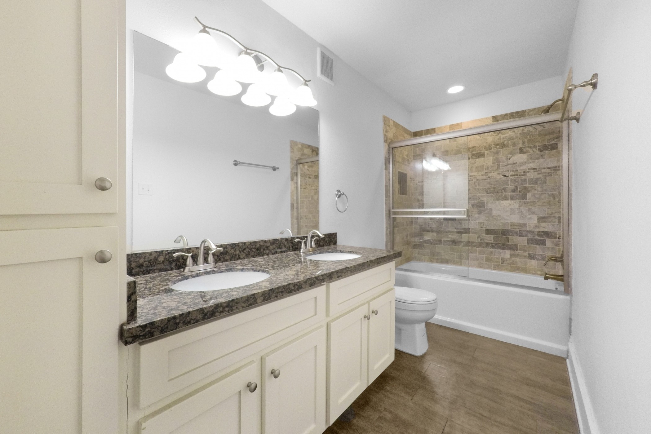 1709 Dan Street Houston, TX 77020 - Photo 21 of 29 a bathroom with a granite countertop sink a toilet a large mirror and bathtub