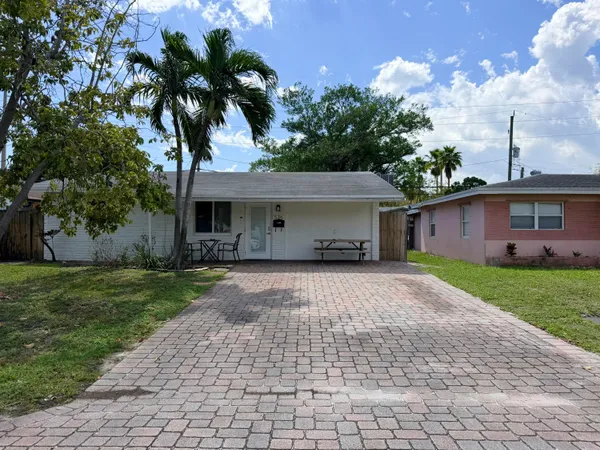 a front view of a house with a garden and trees