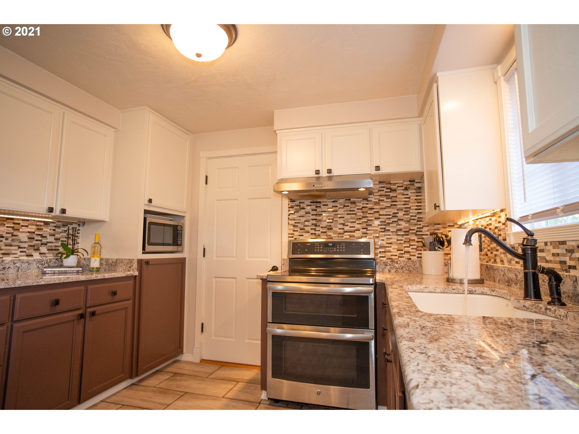 3950 Jasper Road Springfield, OR 97478 - Photo 5 of 20 a kitchen with stainless steel appliances kitchen island granite countertop a stove a sink and a microwave