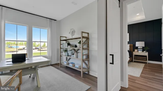 a view of a livingroom with workspace and a window