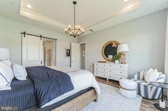 a spacious bedroom with a bed and dresser with mirror