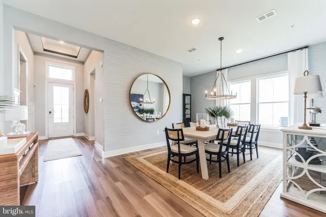 a dining room with wooden floor a glass table and chairs