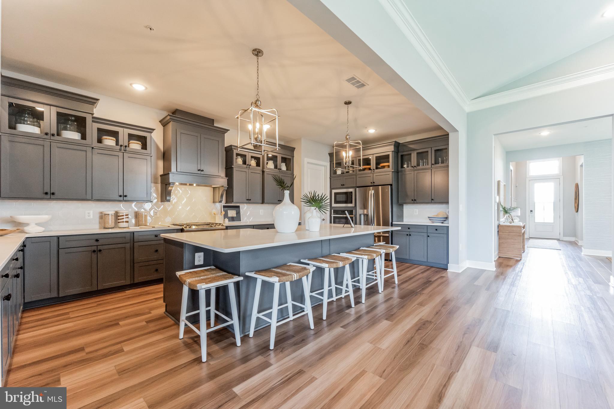 117 Flycatcher Way Stevensville, MD 21666 - Photo 9 of 49 a open kitchen with stainless steel appliances granite countertop a kitchen island a stove a table and chairs in it