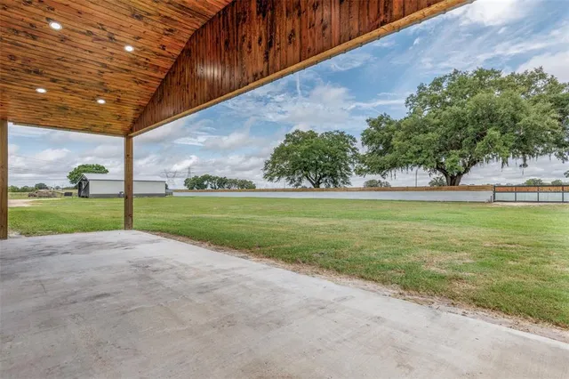 a view of a house with backyard and a tree