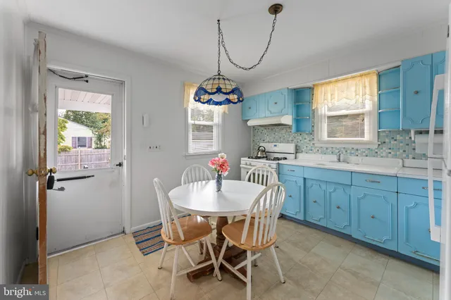 a kitchen with a dining table chairs and cabinets