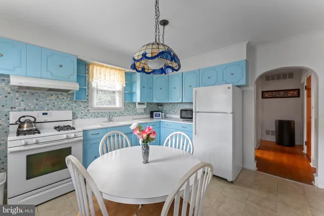 a kitchen with stainless steel appliances granite countertop a refrigerator a stove a sink dishwasher and white cabinets with wooden floor