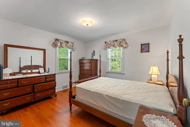 a bedroom with a bed and a dresser next to a window