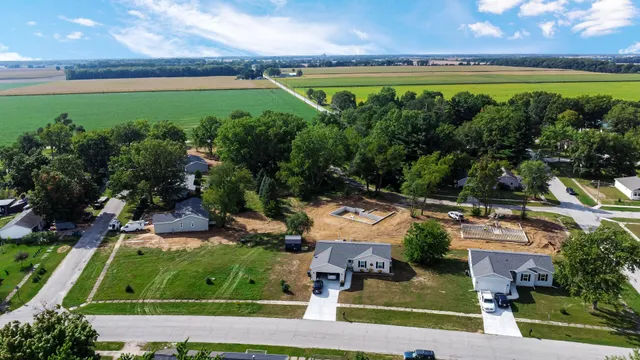 an aerial view of a house with a garden and lake view