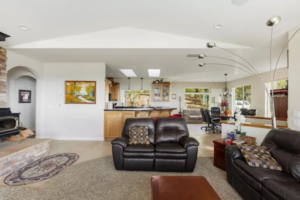 a living room with furniture kitchen and a chandelier
