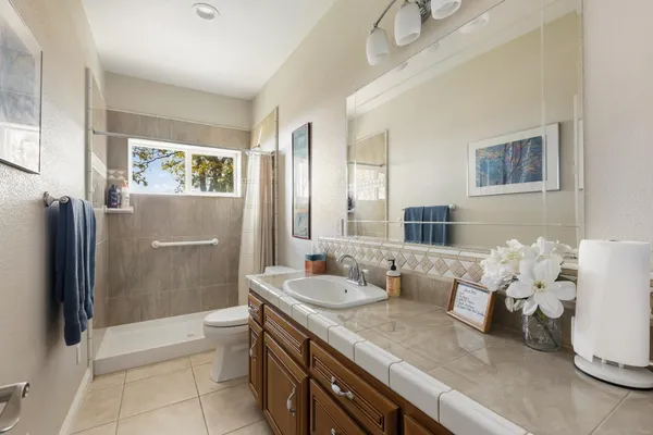 a living room with furniture a ceiling fan and a large window