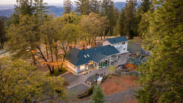 an aerial view of a house with a yard and tree s