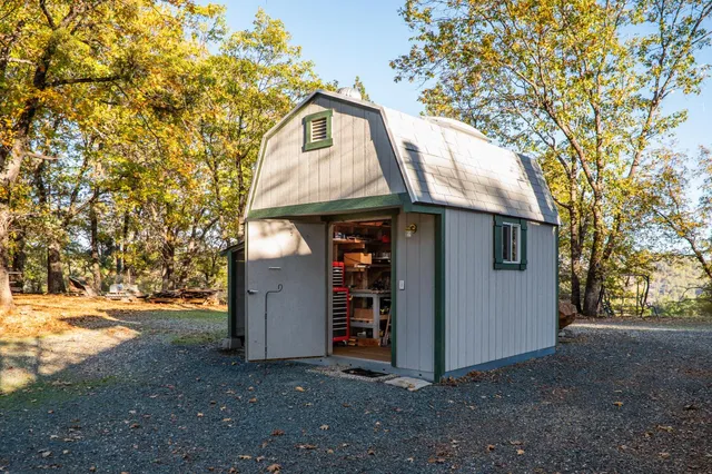 a view of dirt yard with trees