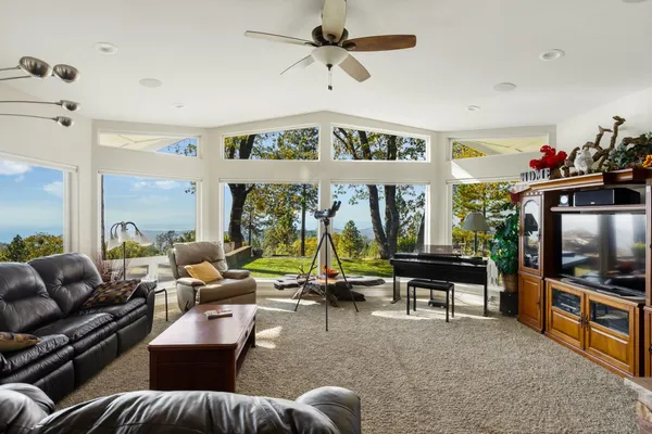 a living room with furniture a flat screen tv and a large window