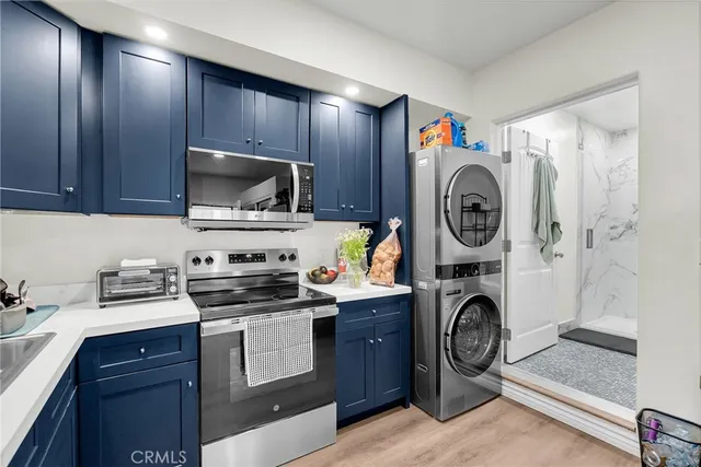 a kitchen with stainless steel appliances a stove a microwave a sink and cabinets