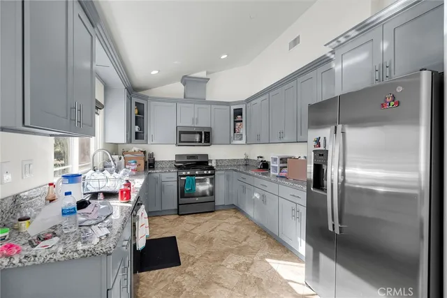 a kitchen with stainless steel appliances granite countertop a refrigerator sink and cabinets
