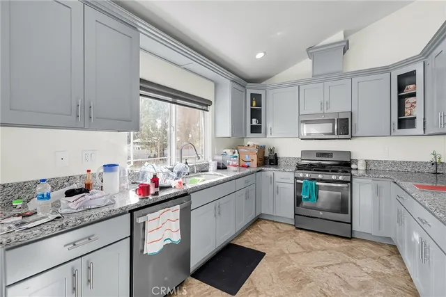 a kitchen with granite countertop a sink stainless steel appliances and cabinets