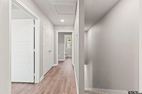 a view of a hallway with wooden floor