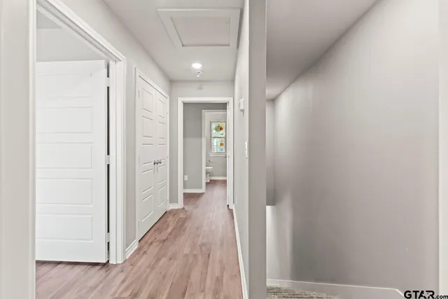a view of a hallway with wooden floor