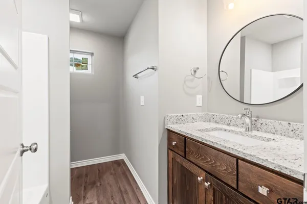 a bathroom with a granite countertop sink and a mirror