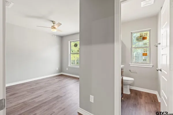 a view of an empty room with a window and wooden floor