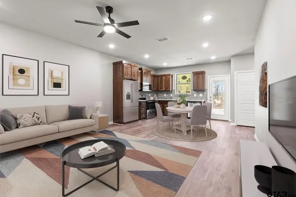 a living room with furniture a refrigerator and kitchen view