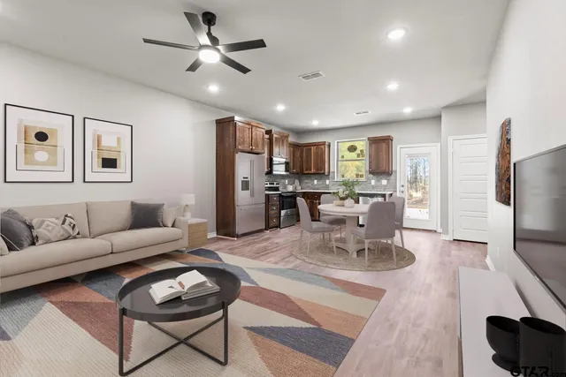 a living room with furniture a refrigerator and kitchen view