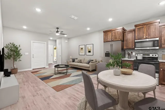 a living room with furniture and a dining table with kitchen view
