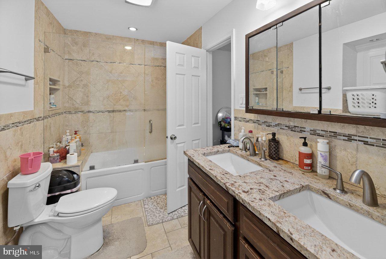 423 Cannon Court, Unit 423 Chesterbrook, PA 19087 - Photo 13 of 26 a bathroom with a granite countertop sink mirror vanity bathtub and a toilet