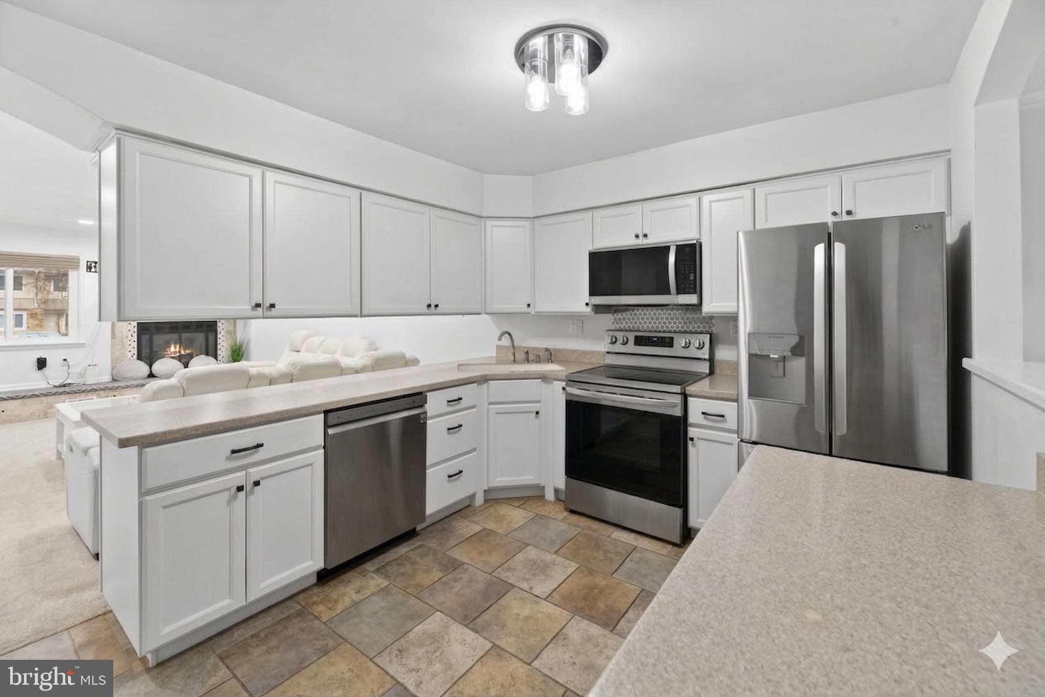 423 Cannon Court, Unit 423 Chesterbrook, PA 19087 - Photo 6 of 26 a kitchen with granite countertop a refrigerator stove and microwave