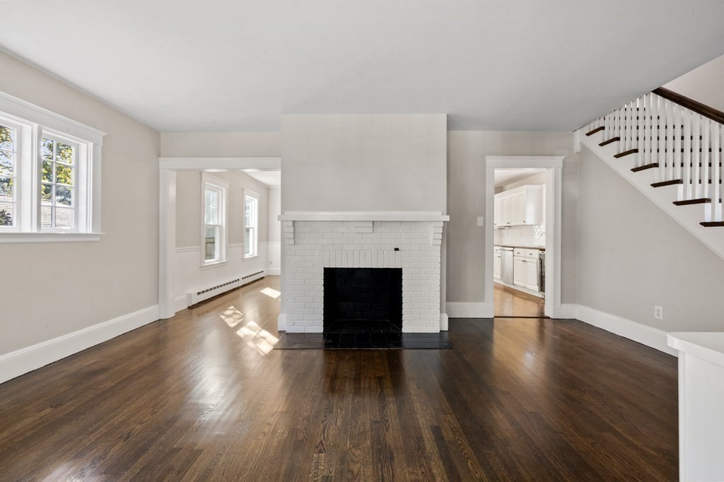 3 Dexter Road Wellesley, MA 02482 - Photo 5 of 40 an empty room with wooden floor fireplace and windows