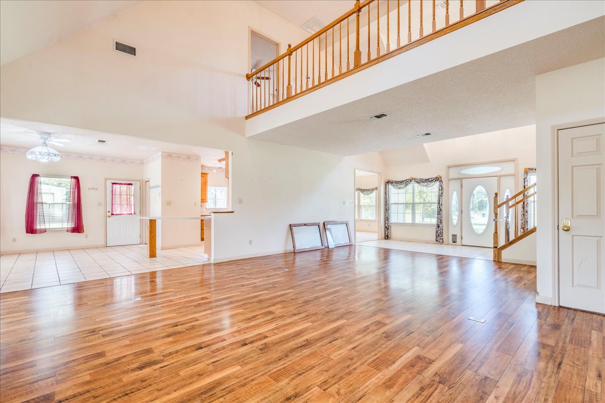 19106 Eyerley Road Manor, TX 78653 - Photo 6 of 40 A grand entrance welcomes guests, featuring rich wood flooring and a soaring vaulted ceiling.