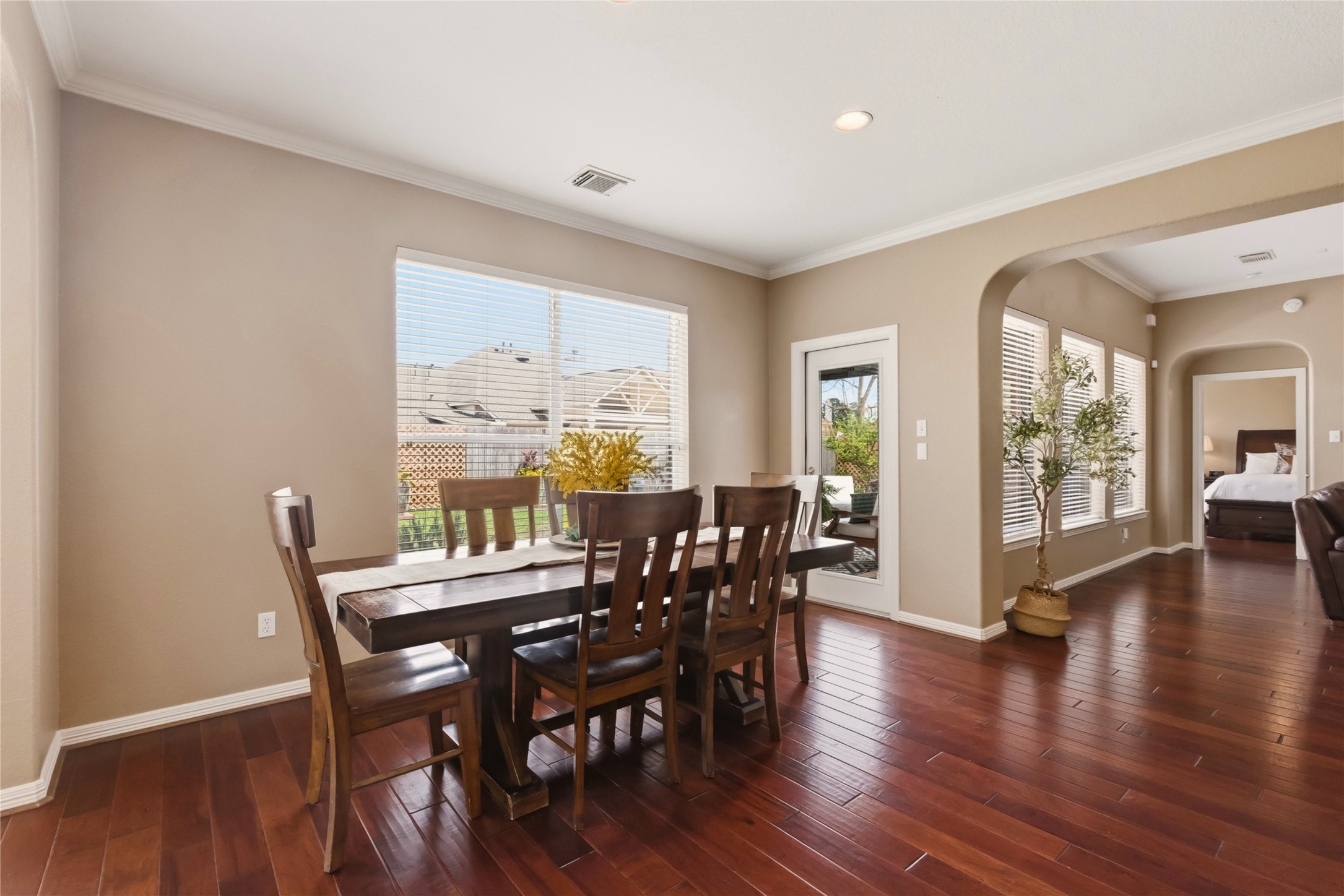 20722 Windrose Bend Drive Spring, TX 77379 - Photo 17 of 50 Your casual dining area with amazing wood flooring, neutral walls, crown molding, and large windows providing ample natural light. The space opens to the cozy living area and the gorgeous kitchen, enhancing the open-concept feel.