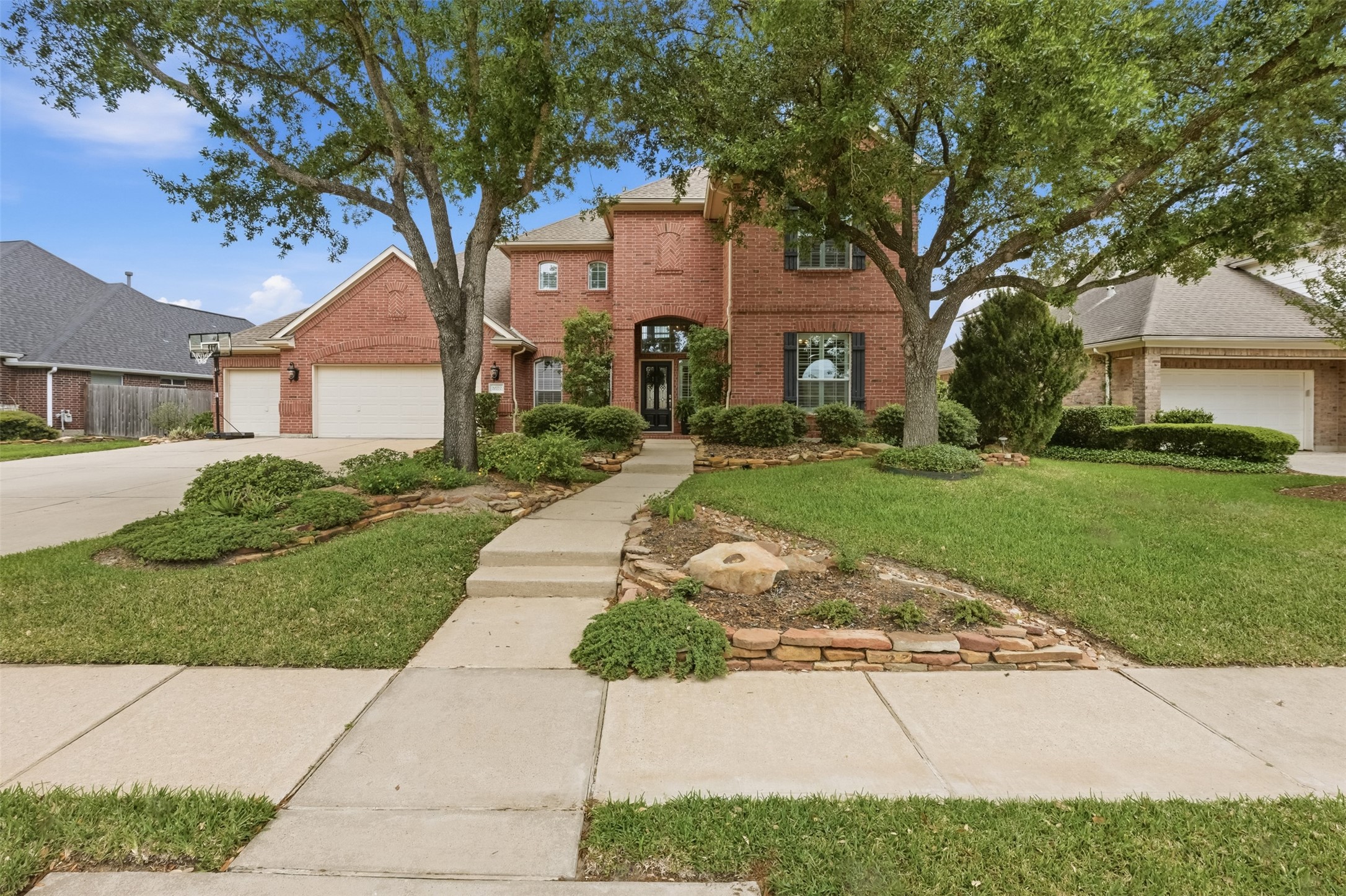 20722 Windrose Bend Drive Spring, TX 77379 - Photo 2 of 50 Stroll up the inviting steps to a charming covered porch, framed by majestic oak trees that offer delightful summer shade.