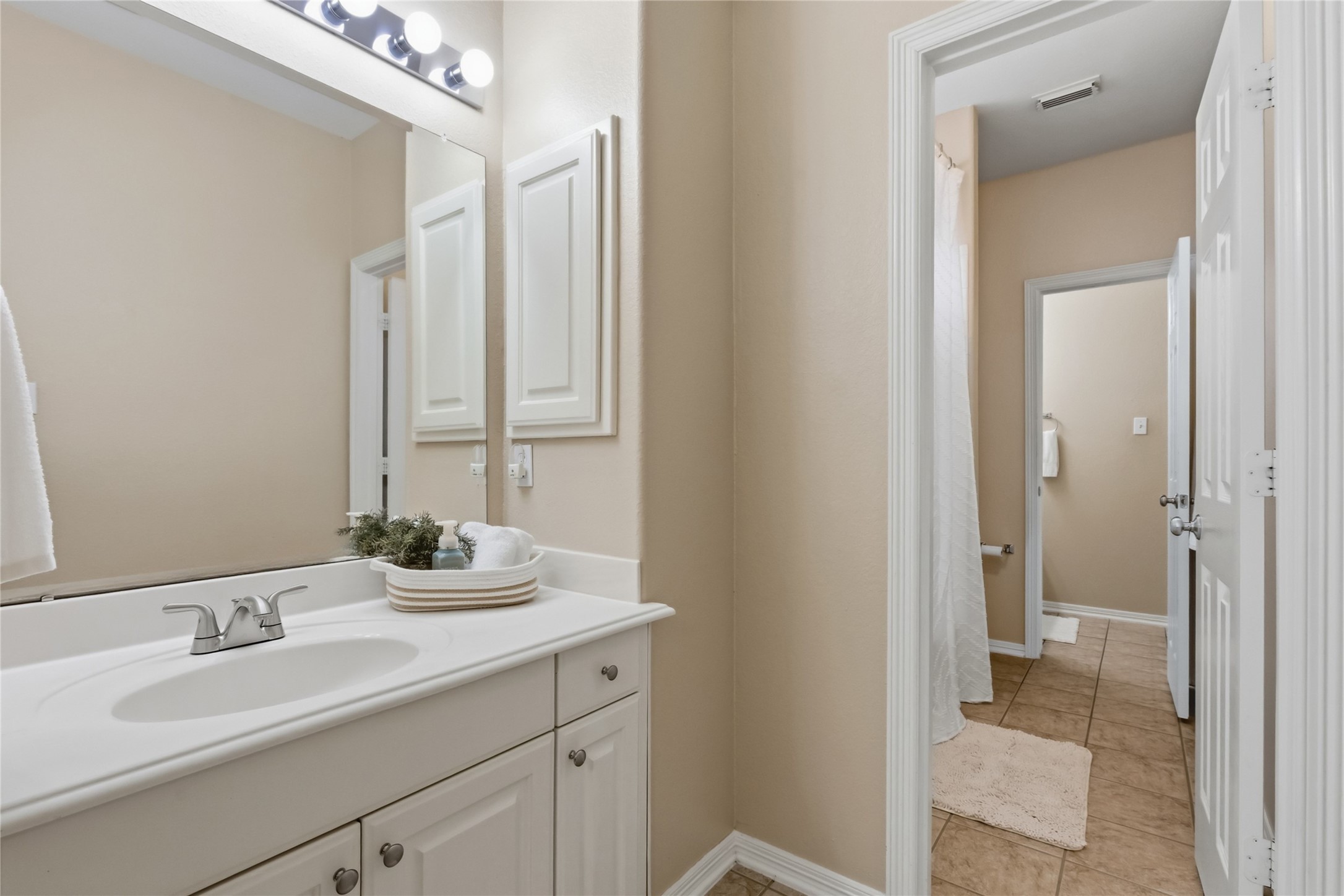 20722 Windrose Bend Drive Spring, TX 77379 - Photo 28 of 50 Function meets design in this charming Jack & Jill bathroom, featuring personal sink & vanity areas on either side of the private wet zone containing the tub/shower combo & lavatory. Neutral tile flooring seamlessly connects the two bedrooms for convenience & style.