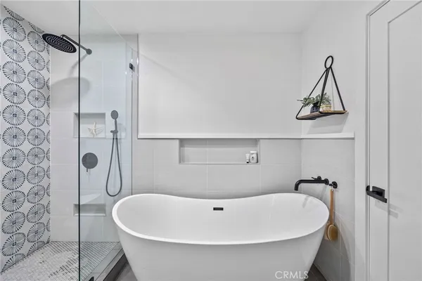 a white bath tub sitting in a bathroom and shower