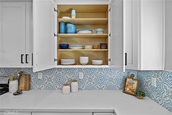 a kitchen with a stove and a wooden floor