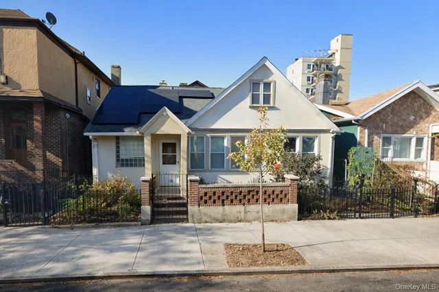 a view of a house with a small yard and potted plants