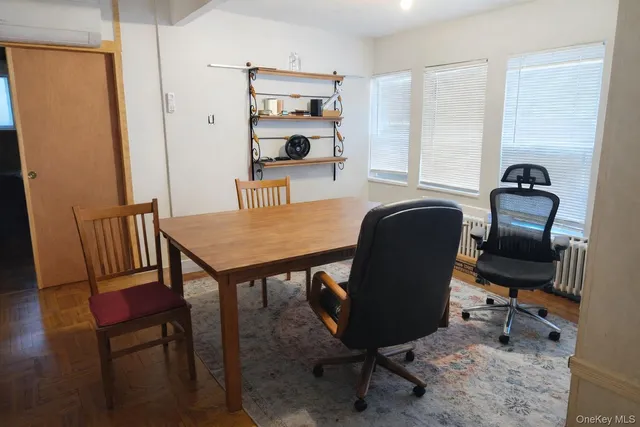a view of a workspace with furniture and a window