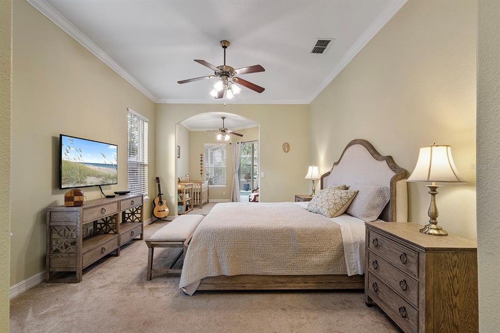 5713 Oak Lake Trail Oviedo, FL 32765 - Photo 20 of 52 a spacious bedroom with a bed a couch and a flat tv screen on dresser
