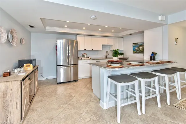a kitchen with granite countertop stainless steel appliances a refrigerator and a stove top oven