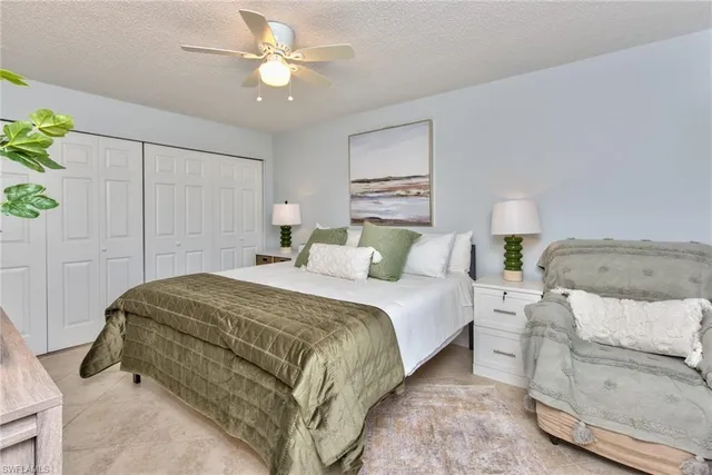 a bedroom with a bed and a ceiling fan